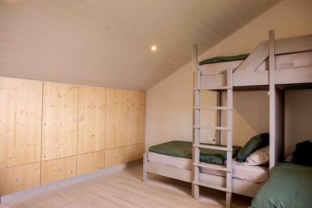 Chambre à l'étage, lit double et rangements.