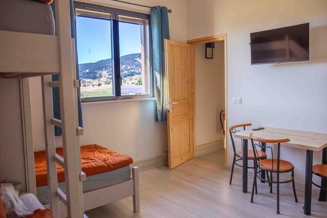 Chambre à l'étage, lit double et commode.