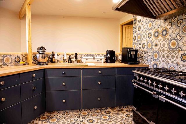 Cuisine équipée : piano gaz, plan de travail, électroménager.